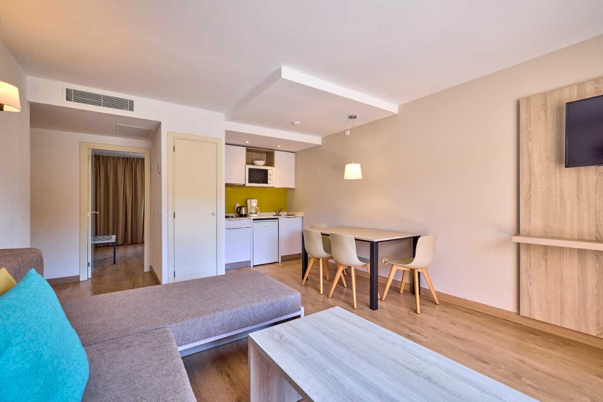 espaciosa sala de estar con sofa cama y mesa de comedor en apartamento de un dormitorio de universal apartamentos Canyamel garden