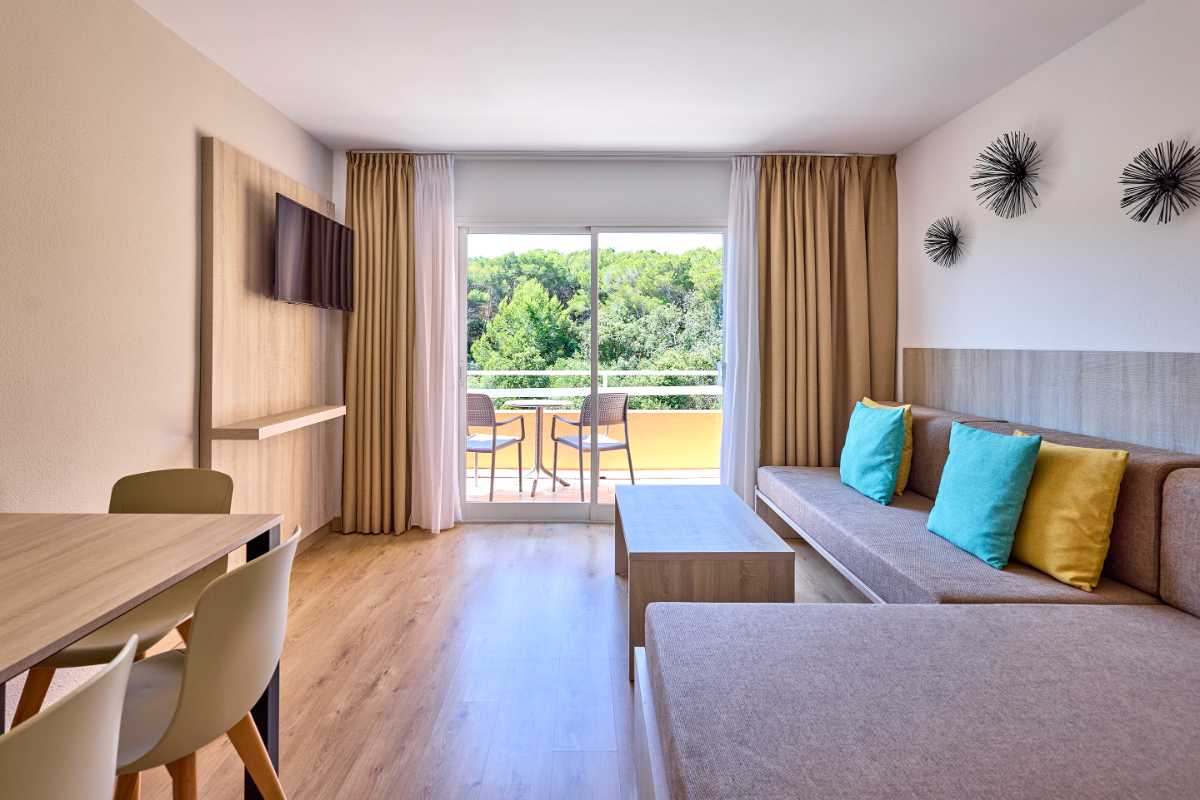 sala de estar con escritorio y sofa en apartamento de un dormitorio de universal apartamentos Canyamel garden