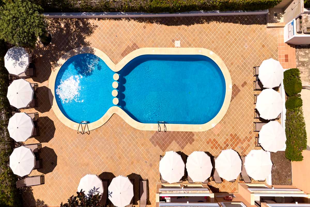 vista aerea de las piscinas con solarium y sombrillas en universal apartamentos Canyamel garden