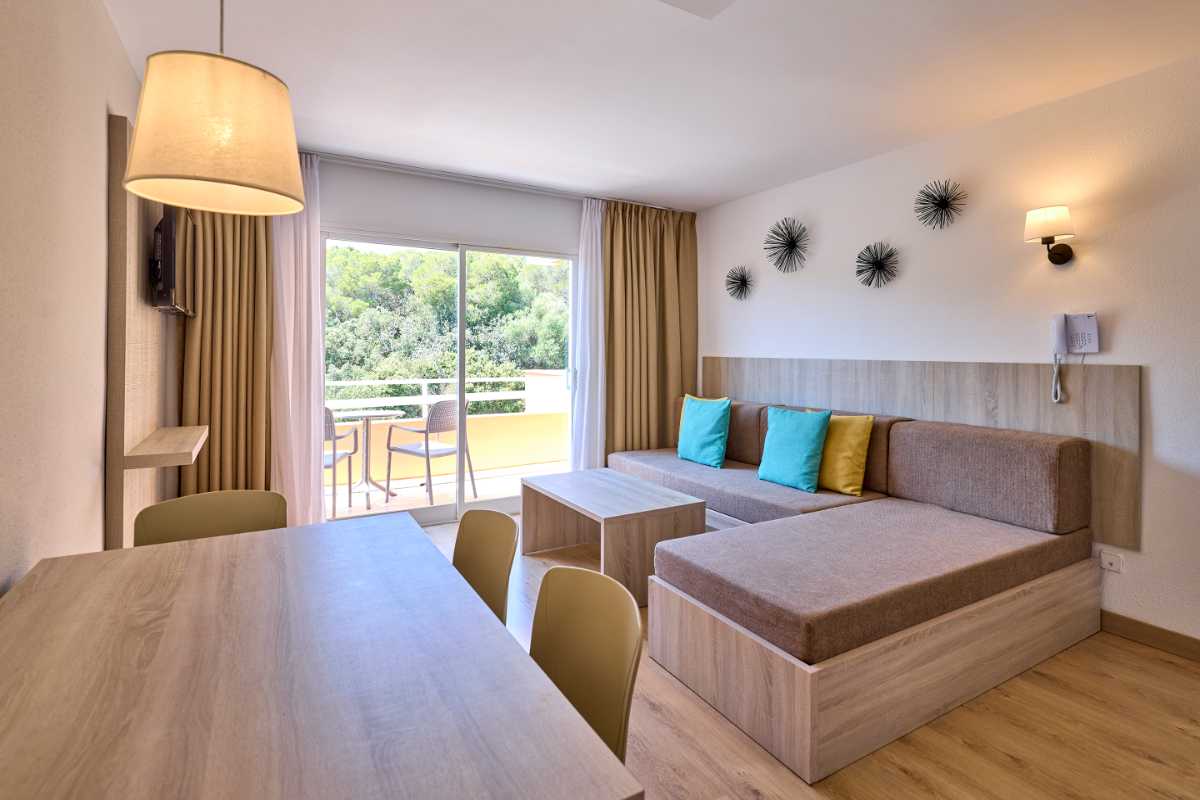 sofa cama y escritorio en sala de estar del apartamento de un dormitorio en universal apartamentos Canyamel garden
